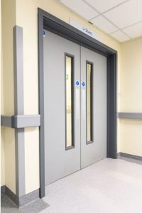 A set of grey fire doors positioned in what appears to be a hospital setting.