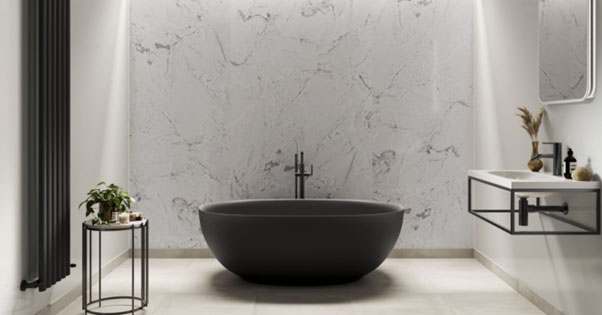 A black modern bath tub in the centre of the room.