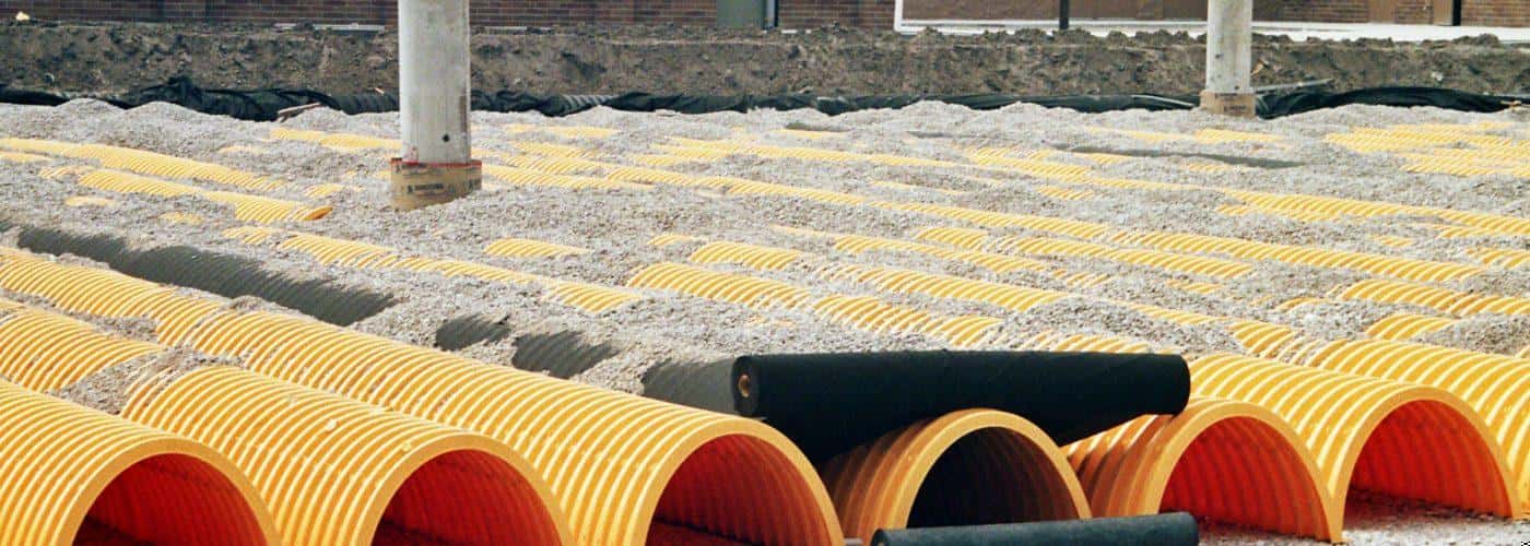 Yellow pipes sticking out of wet cement. 