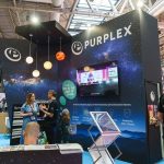 Purplex Marketing's space-themed stand at FIT Show 2025 with people interacting and a